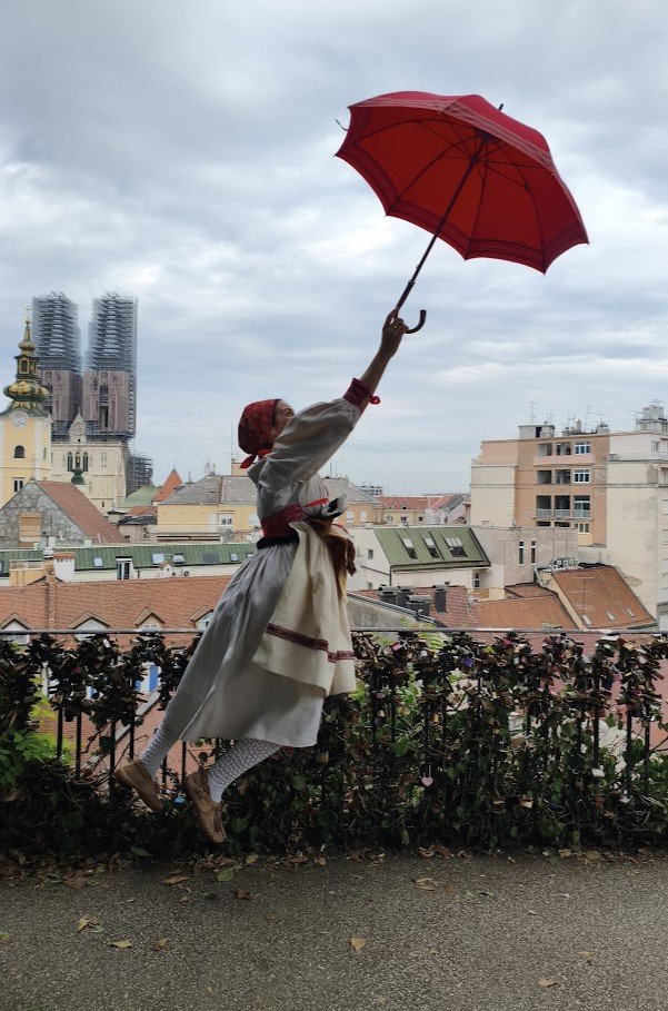 lady flying off with a red umbrella